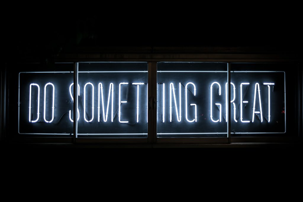 a sign that reads "do something great" winning business