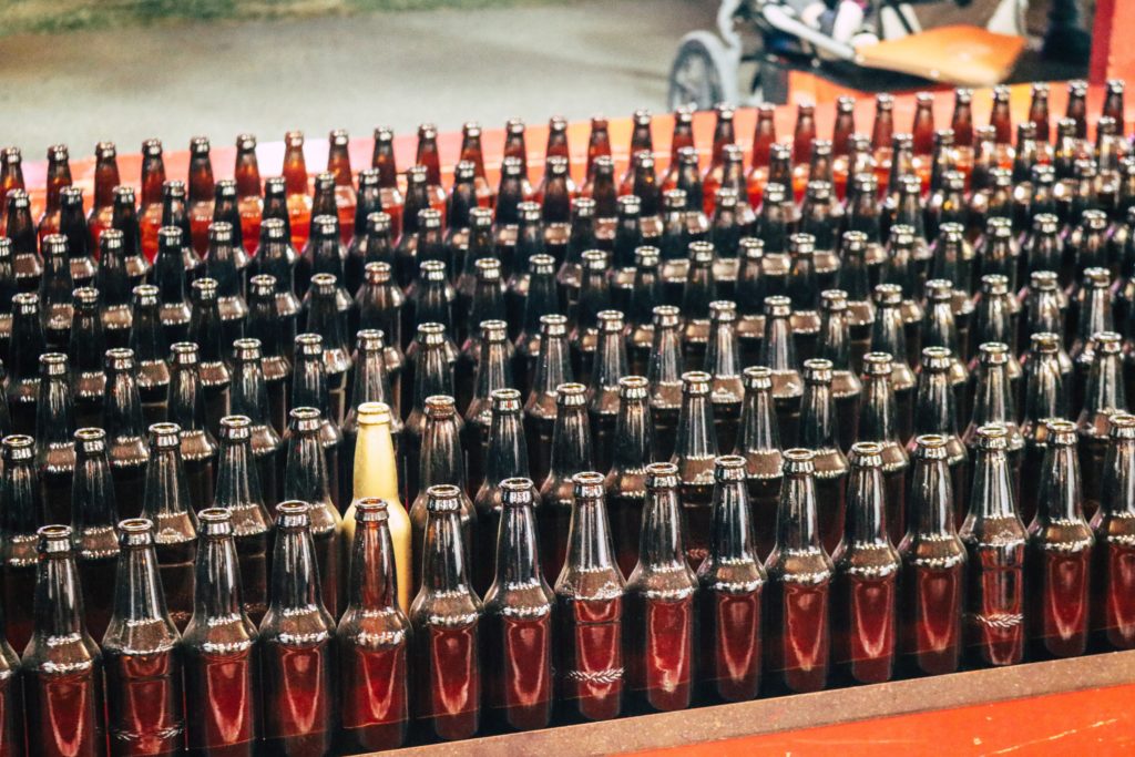 a series of bottles with one standing out from the rest of the pack to show how to stand out to win business