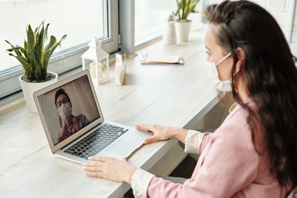 Woman completing RFP response online with mask