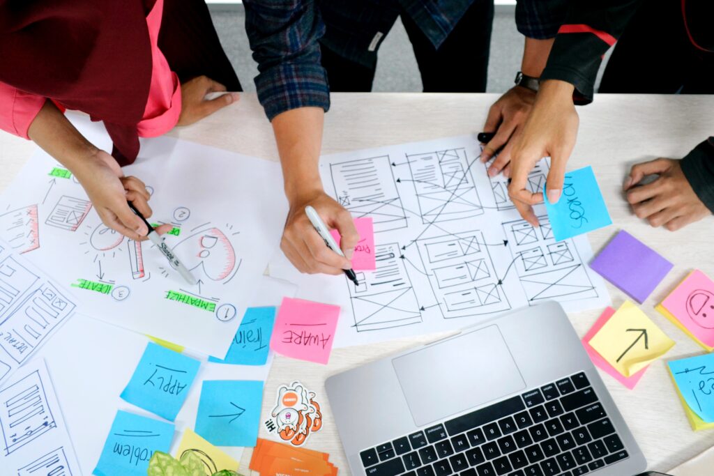 people collaborating on a project with post-its and papers on the desk 