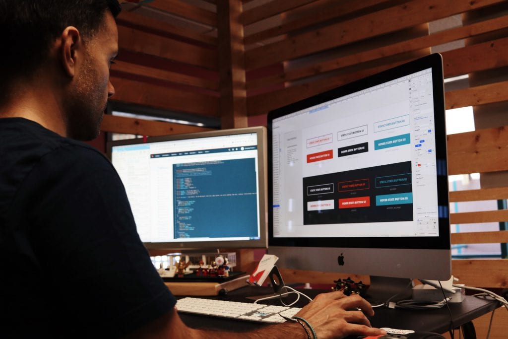 A man working on two computer screens