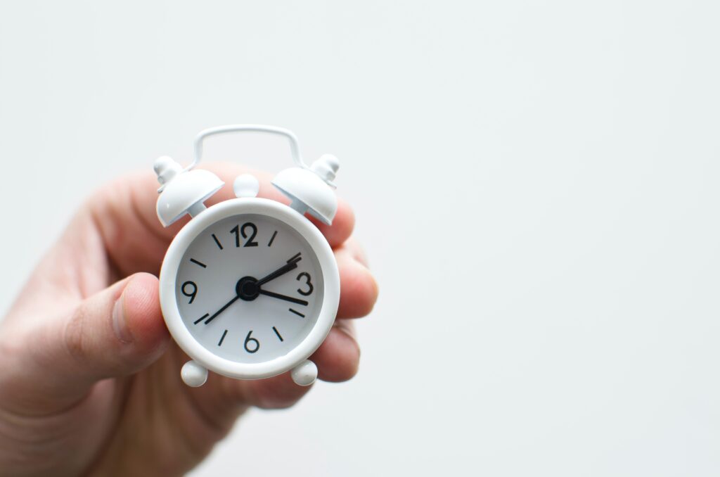 hand holding a clock to show proposal management deadlines